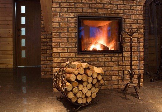 The picture shows a heating fireplace with a laying of firewood for it